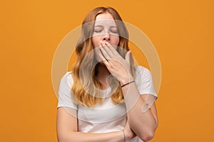 Young beautiful woman with wavy redhead bored yawning tired covering mouth with hand. Restless and sleepiness