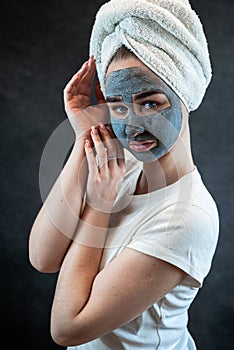 young beautiful woman wear white towel doing beauty wellness treatment with black clay facial mask