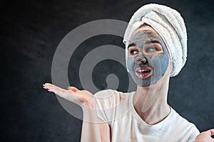 young beautiful woman wear white towel doing beauty wellness treatment with black clay facial mask