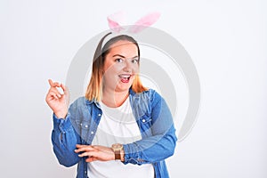 Young beautiful woman wearing banny ears standing over isolated white background with a big smile on face, pointing with hand and