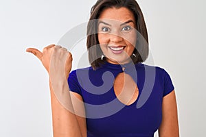 Young beautiful woman wearing blue elegant t-shirt standing over isolated white background pointing and showing with thumb up to