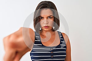 Young beautiful woman wearing blue striped t-shirt standing over isolated white background pointing with finger to the camera and