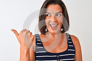 Young beautiful woman wearing blue striped t-shirt standing over isolated white background pointing and showing with thumb up to