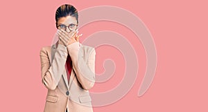 Young beautiful woman wearing business shirt and glasses shocked covering mouth with hands for mistake