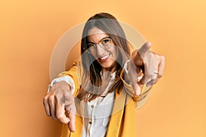 Young beautiful woman wearing business style and glasses pointing to you and the camera with fingers, smiling positive and