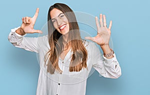 Young beautiful woman wearing casual clothes showing and pointing up with fingers number seven while smiling confident and happy