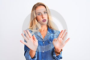 Young beautiful woman wearing casual denim shirt standing over isolated white background Moving away hands palms showing refusal