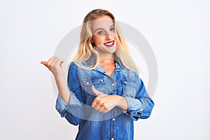 Young beautiful woman wearing casual denim shirt standing over isolated white background Pointing to the back behind with hand and