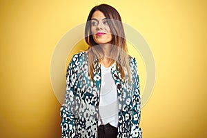 Young beautiful woman wearing casual jacket over yellow isolated background smiling looking to the side and staring away thinking