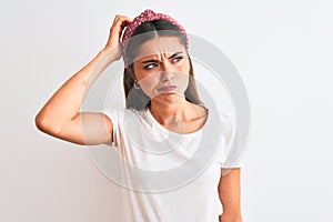 Young beautiful woman wearing casual t-shirt and diadem over isolated white background confuse and wonder about question