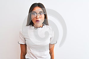 Young beautiful woman wearing casual t-shirt and glasses over isolated white background afraid and shocked with surprise