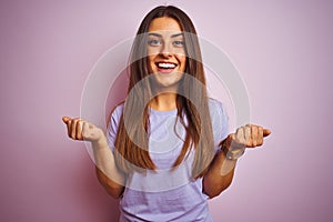 Young beautiful woman wearing casual t-shirt standing over isolated pink background celebrating surprised and amazed for success