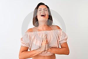Young beautiful woman wearing casual t-shirt standing over isolated white background begging and praying with hands together with