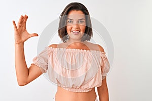 Young beautiful woman wearing casual t-shirt standing over isolated white background smiling and confident gesturing with hand