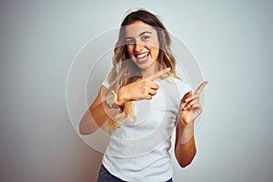 Young beautiful woman wearing casual white t-shirt over isolated background smiling and looking at the camera pointing with two