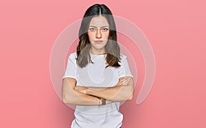 Young beautiful woman wearing casual white t shirt skeptic and nervous, disapproving expression on face with crossed arms