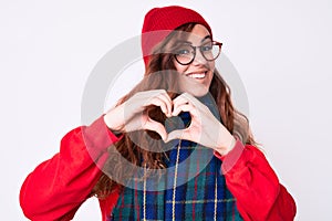 Young beautiful woman wearing casual winter scarf and glasses smiling in love showing heart symbol and shape with hands