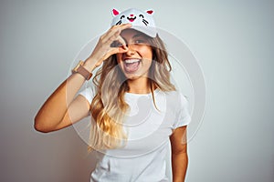 Young beautiful woman wearing cat cap over grey  background with happy face smiling doing ok sign with hand on eye looking