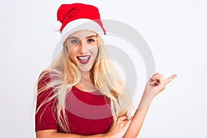 Young beautiful woman wearing Christmas Santa hat over isolated white background with a big smile on face, pointing with hand and