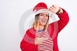 Young beautiful woman wearing Christmas Santa hat over isolated white background smiling making frame with hands and fingers with