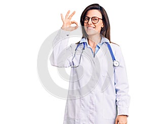 Young beautiful woman wearing doctor stethoscope and glasses smiling positive doing ok sign with hand and fingers