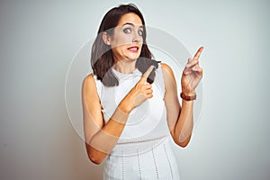 Young beautiful woman wearing dress standing over white isolated background Pointing aside worried and nervous with both hands,