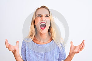 Young beautiful woman wearing elegant blue t-shirt standing over isolated white background crazy and mad shouting and yelling with