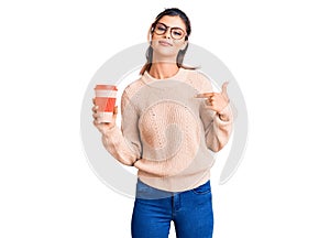 Young beautiful woman wearing glasses holding takeaway cup of coffee pointing finger to one self smiling happy and proud