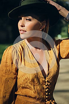 Young beautiful woman wearing hat and thoughtfully looking away. Gorgeous model posing outdoor