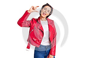 Young beautiful woman wearing red leather jacket smiling and confident gesturing with hand doing small size sign with fingers