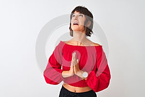 Young beautiful woman wearing red summer t-shirt standing over isolated white background begging and praying with hands together