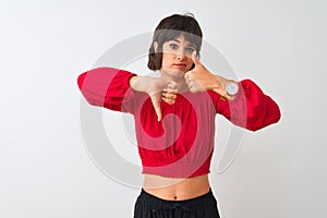 Young beautiful woman wearing red summer t-shirt standing over isolated white background Doing thumbs up and down, disagreement