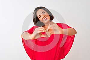 Young beautiful woman wearing red t-shirt standing over isolated white background smiling in love showing heart symbol and shape