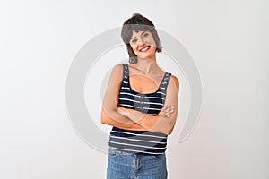 Young beautiful woman wearing striped t-shirt standing over isolated white background happy face smiling with crossed arms looking