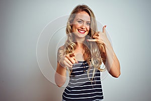 Young beautiful woman wearing stripes t-shirt standing over white isolated background smiling doing talking on the telephone