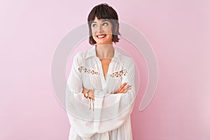 Young beautiful woman wearing summer white shirt standing over isolated pink background smiling looking side and staring away