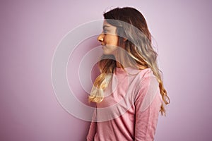 Young beautiful woman wearing a sweater over pink isolated background looking to side, relax profile pose with natural face with