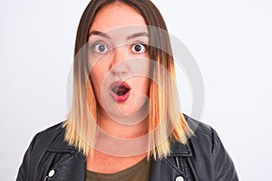 Young beautiful woman wearing t-shirt and jacket standing over isolated white background scared in shock with a surprise face,