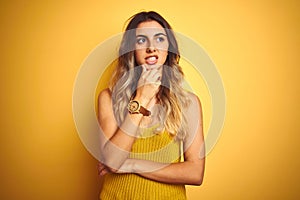 Young beautiful woman wearing t-shirt over yellow isolated background Thinking worried about a question, concerned and nervous