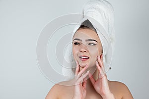 Young beautiful woman wearing white towel on her head standing on isolated white background looking satisfied , morning beauty