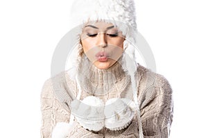 Young beautiful woman wearing winter hat and mittens over white background, blowing kiss with hands on air, love expression