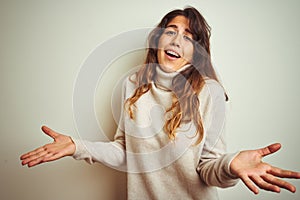 Young beautiful woman wearing winter sweater standing over white isolated background smiling cheerful with open arms as friendly