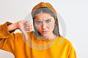 Young beautiful woman wearing yellow sweater and diadem over isolated white background with angry face, negative sign showing