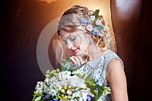 Young beautiful woman in wedding dress with bouquet of flowers. Wedding hairstyle, flowers in hair.