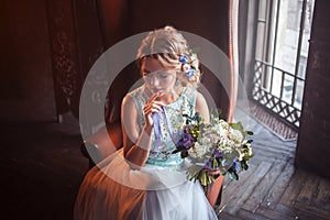 Young beautiful woman in wedding dress with bouquet of flowers. Wedding hairstyle, flowers in hair.