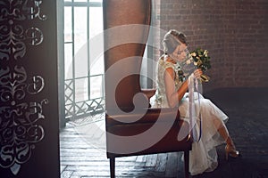 Young beautiful woman in wedding dress with bouquet of flowers. Wedding hairstyle, flowers in hair.
