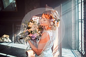 Young beautiful woman in wedding dress with bouquet of flowers. Wedding hairstyle, flowers in hair.