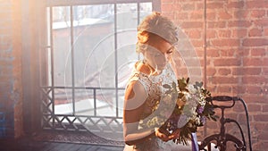 Young beautiful woman in wedding dress with bouquet of flowers. Wedding hairstyle, flowers in hair.