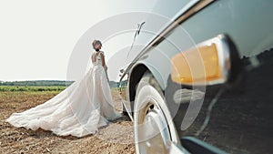 Young Beautiful Woman In Wedding Dress Posing Near Vintage Car.