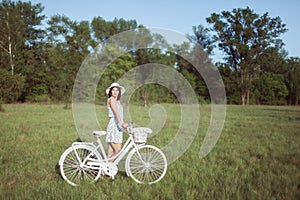 Young beautiful woman with a white bicycle.